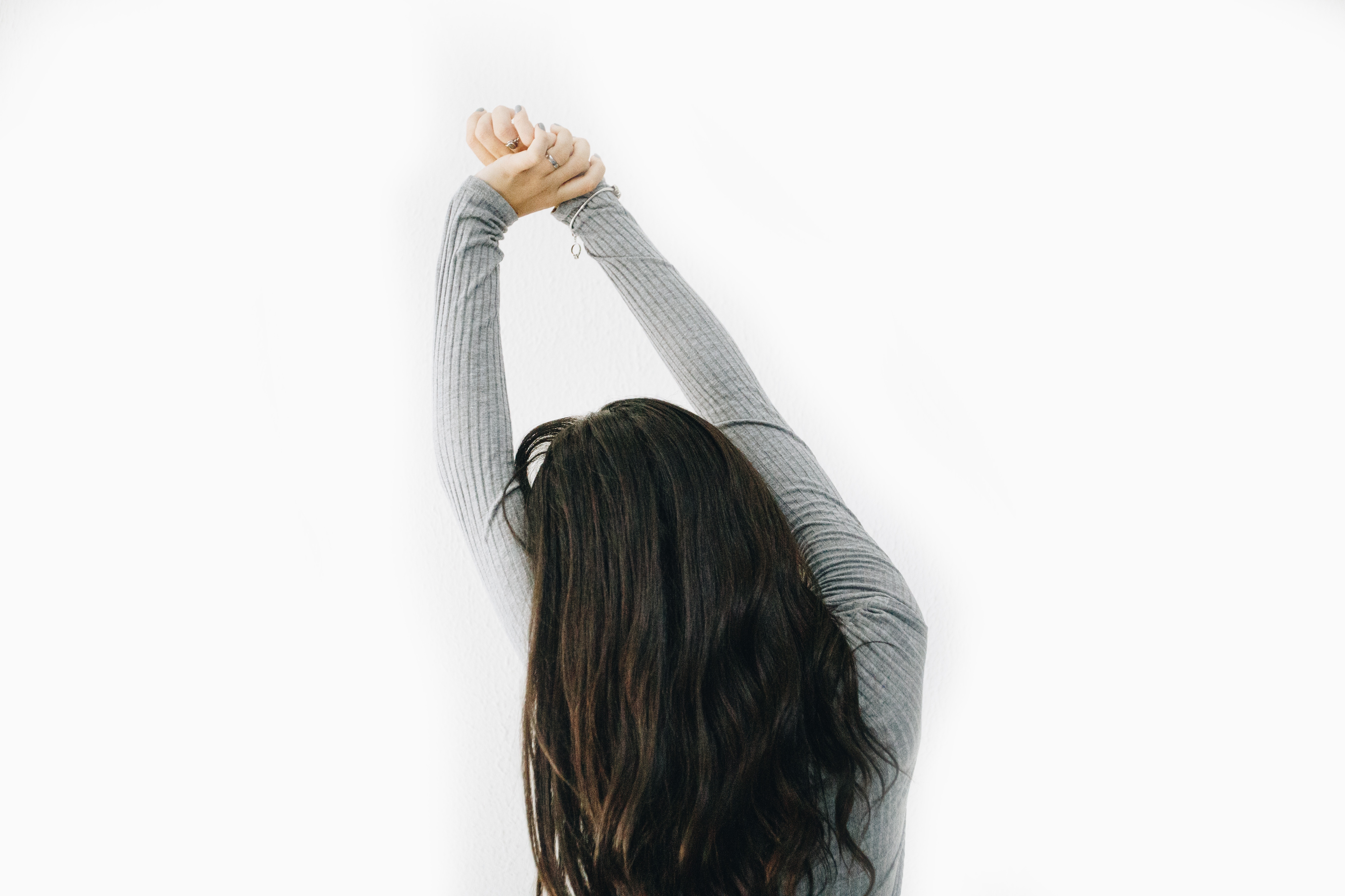 Wake up feeling energised: person stretching their arms up over their head from behind.