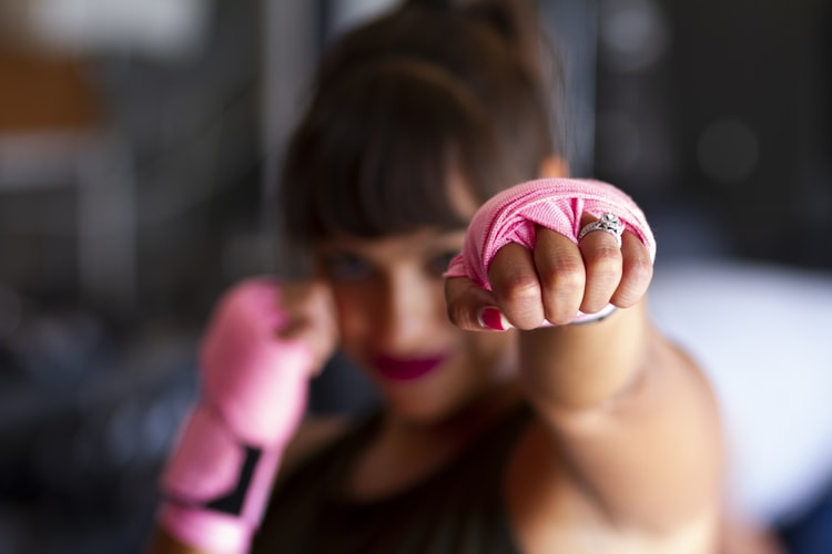 A woman punching out one hand in front of her face