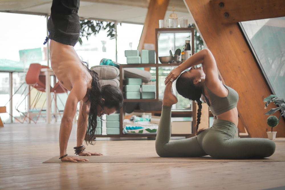 Movement snacking man handstanding and woman in yoga pose in the office
