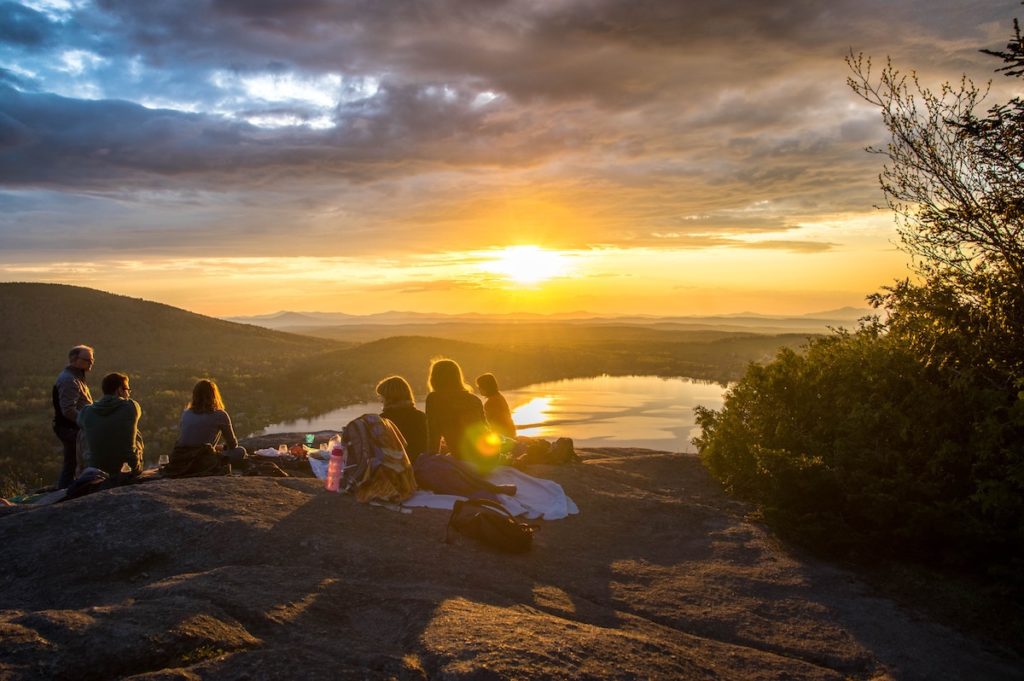 Future Retrospection people sat on a hilltop at sunset