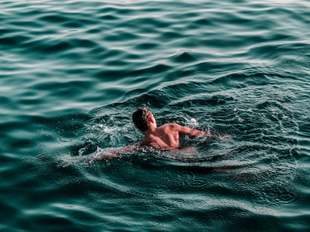 person swimming in the sea Cold water immersion preventative health strategies