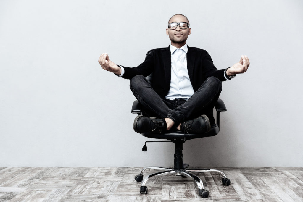 Maintaining Healthy Habits In Hybrid Working man meditating in work chair