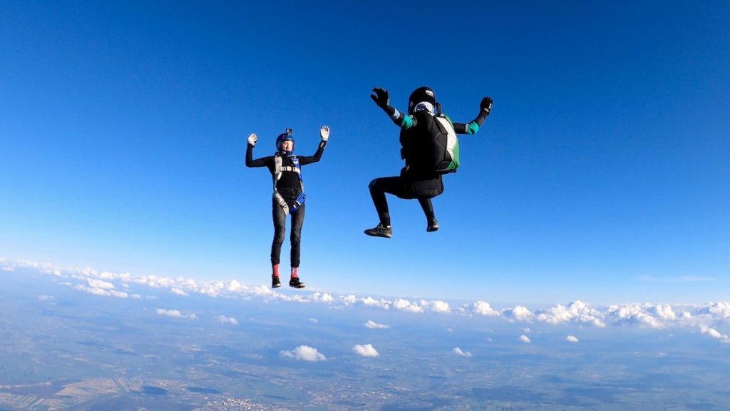 jumping without a parachute - two people sky diving with their parachutes not yet open