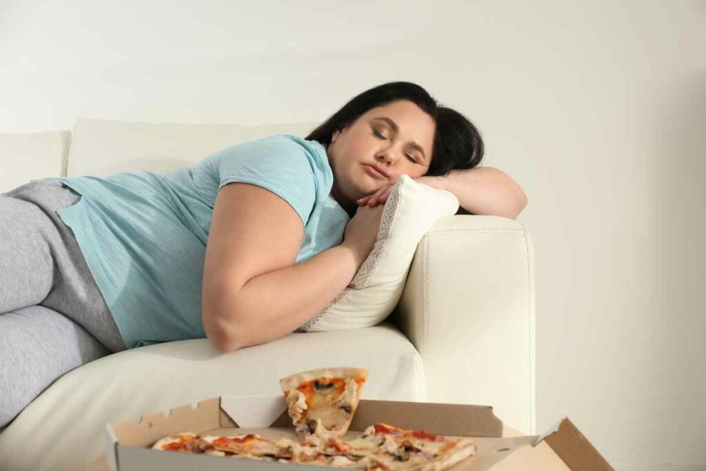 blood glucose levels and mood - woman sleeping after eating pizza