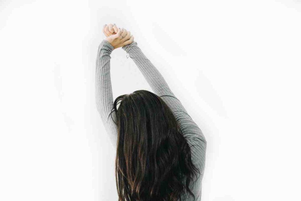 person stretching arms above head - 7 ways to wake up energised