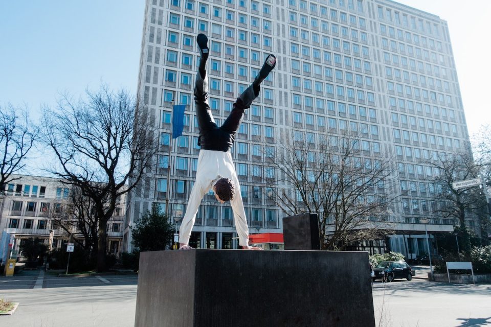 Business Athlete - man in short and suit doing a handstand