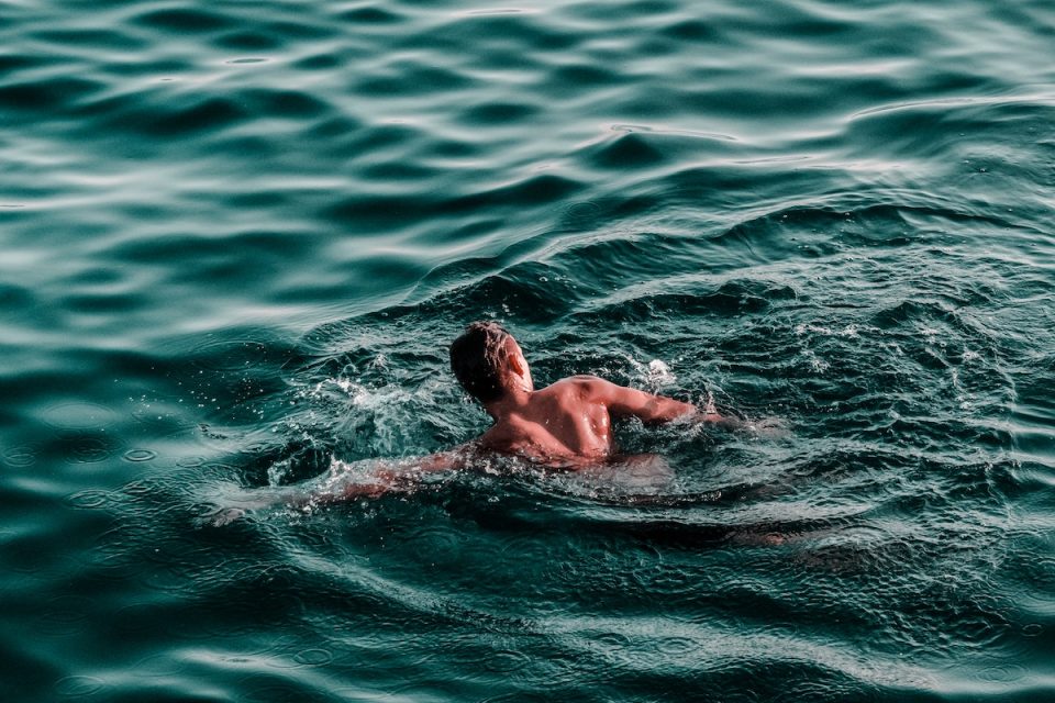 person swimming in the sea Cold water immersion preventative health strategies