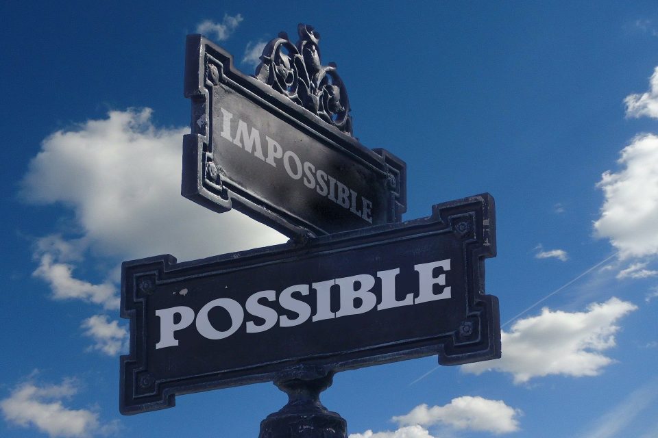 A signpost with one direction saying Impossible and the other direction saying possible