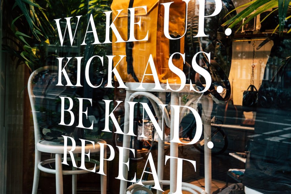 consistency not intensity approach to weelbeing, shop sign saying wake up kick ass be kind repeat