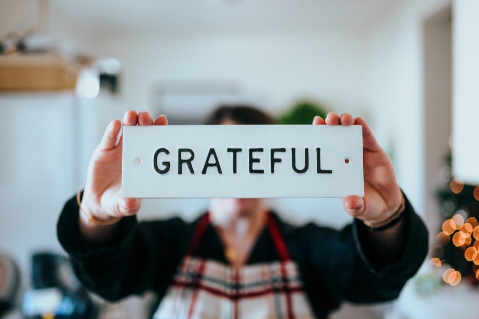Person holding a grateful sign. Five things you are happy and grateful for