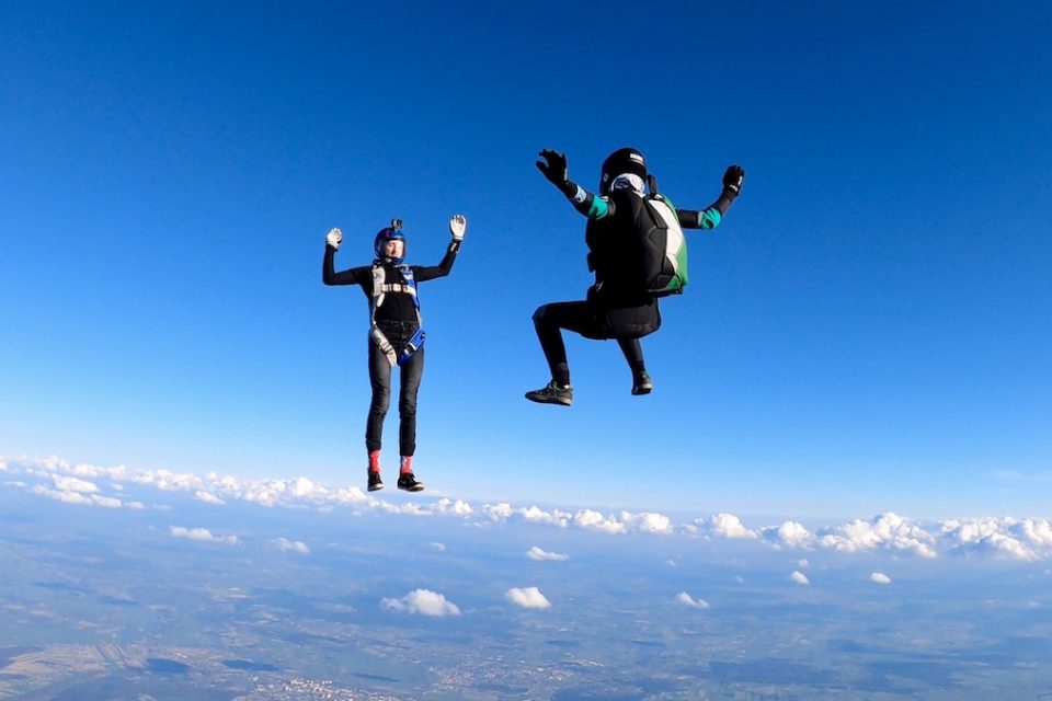 jumping without a parachute - two people sky diving with their parachutes not yet open