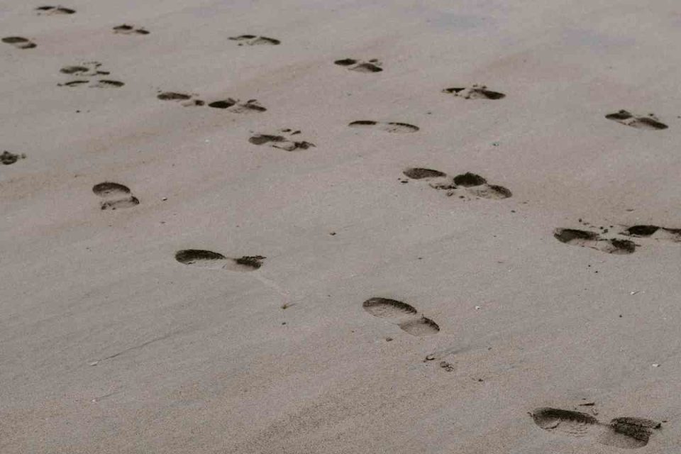 nudge theory to encourage movement: footprints in the sand following the same direction. Bodyshot Performance