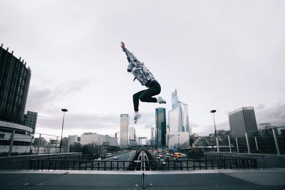 what makes a business athlete podcast woman jumping in a cityscape